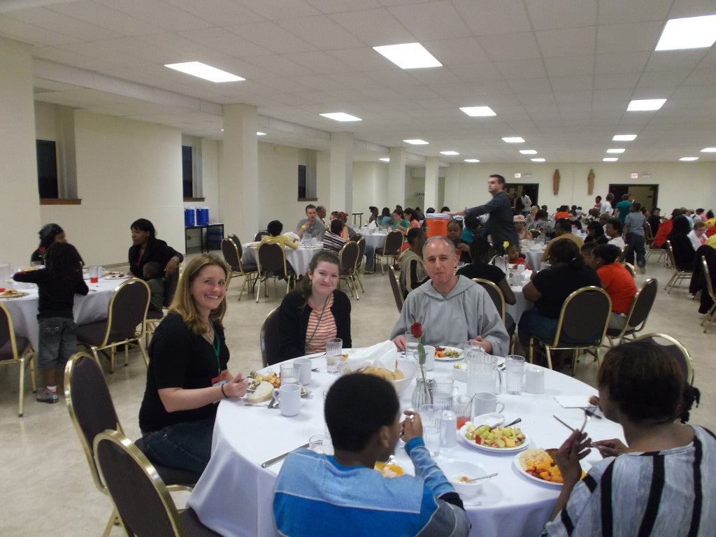 Fr. Bob and volunteers visit with some of our neighbors during the dinner.