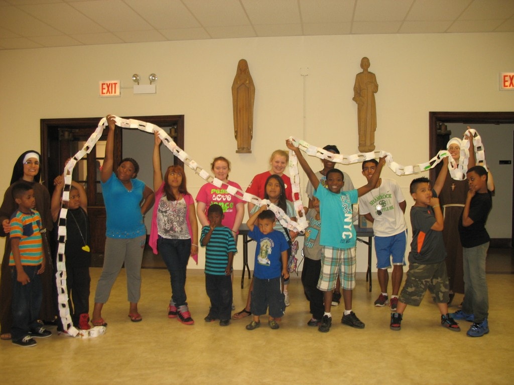 Sr. Alicia and Sr. Stephanie with kids displaying their Gifts of the Holy Spirit Chain.